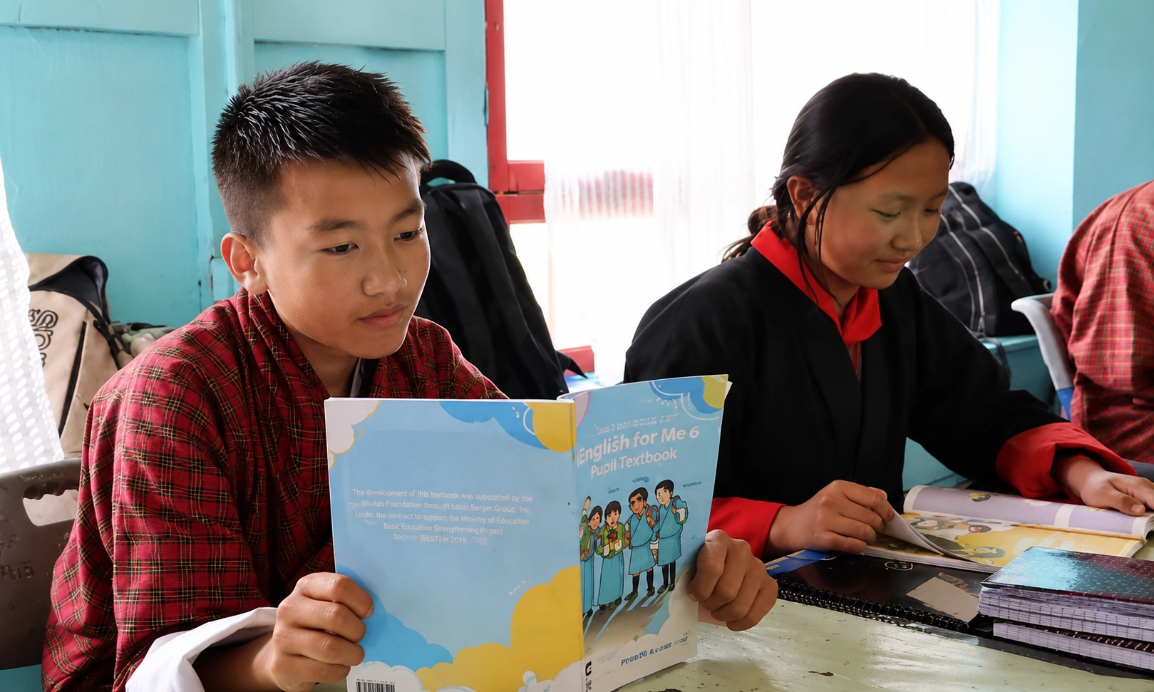 Bhutanese students studying an English textbook together in a classroom